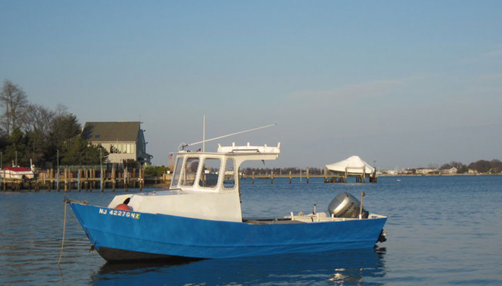 Blue 23 foot widebody Tolman skiff wooden boat